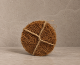 NEEMSAJ natural coir bath scrubber on a stone surface